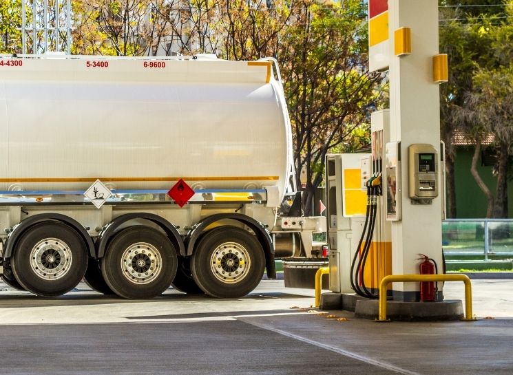Certificações e segurança nas legislações para caminhão-tanque Caminhão-tanque em posto de combustível realizando abastecimento conforme legislações para caminhão-tanque.